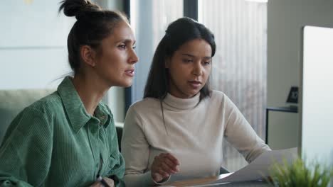 two women working and analyzing something on computer at home