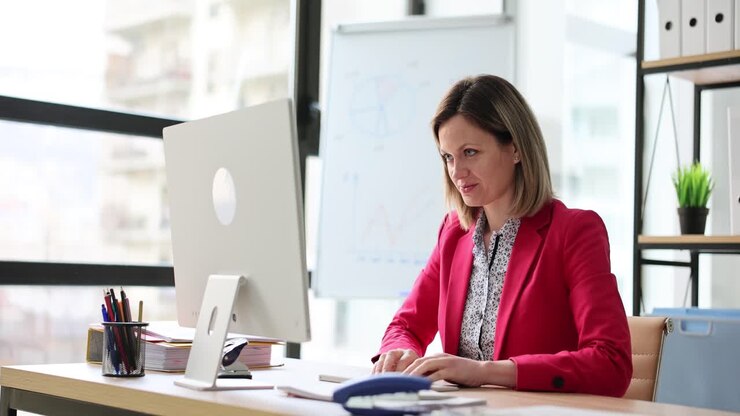 Woman Working at Computer and Stretching Hands in Office