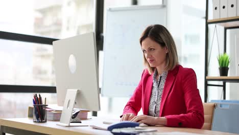 woman working at computer and stretching hands in office