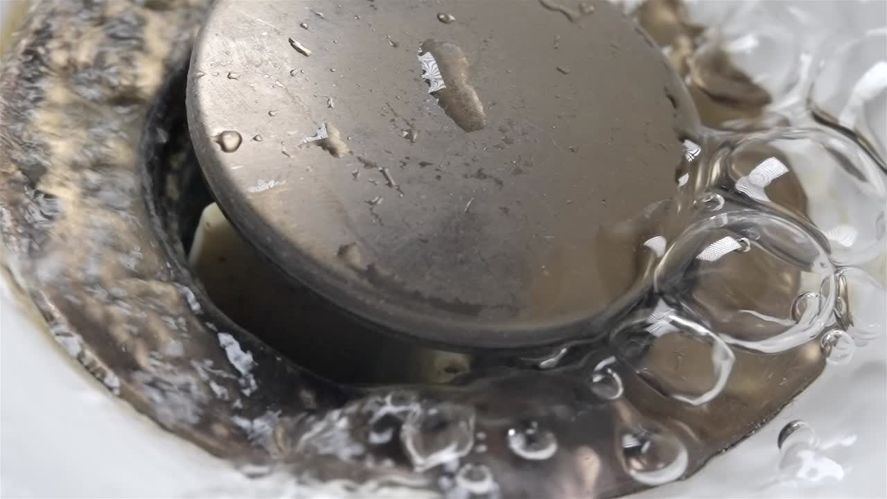 Clean Tap Water Stream Begins to Flow Down Drain Pipe