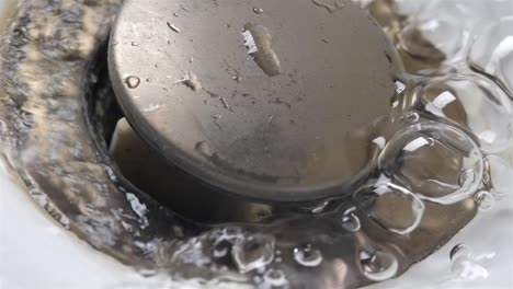 clean tap water stream begins to flow down drain pipe