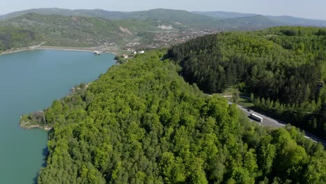 carretera de montaña a través de un denso bosque con vistas al embalse de maneciu en el condado de prahova, muntenia, rumania