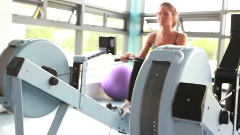 two women drawing on row machine