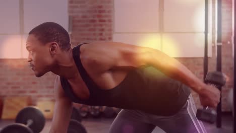 Animation-of-glowing-light-over-fit-man-exercising-in-gym