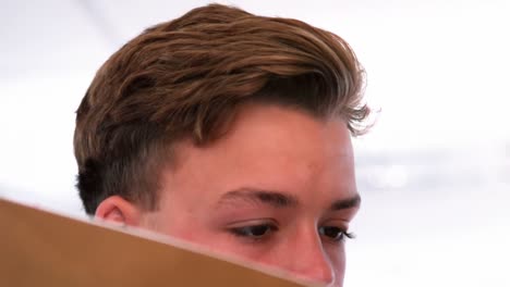 schoolboy reading a book in classroom