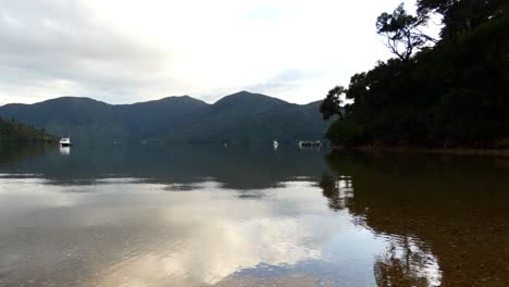 Beautiful-early-morning-golden-hour-reflection-of-sea,-sky-and-land-at-entrance-to-secluded-cove---Camp-Bay,-Endeavour-Inlet