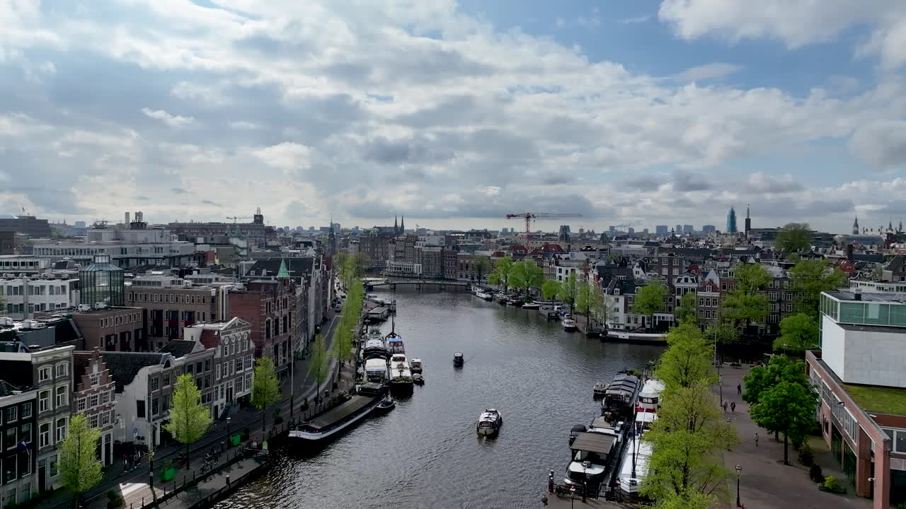 The drone is flying forward going up above the Amstel canal in the city centre of Amsterdam The Netherlands Aerial Footage 4K