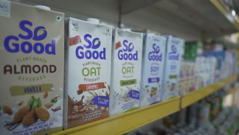 customer choosing vegan plant based soy and oat milk beverage unsweetened tetra pack, handheld shot