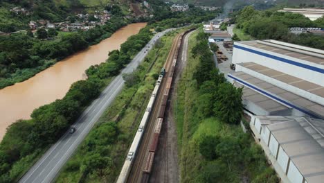 Train-crossing-under-a-concrete-bridge-with-cars