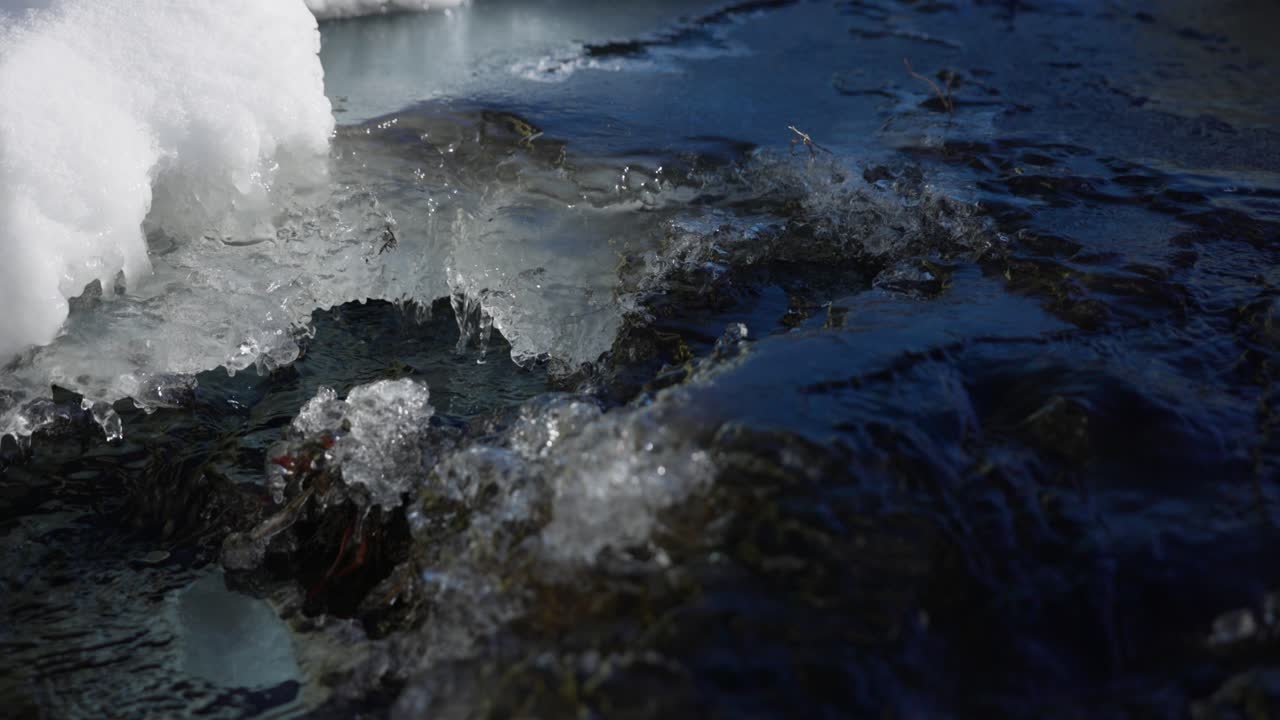 Close up of small stream during spring thaw with water from melting ice ...