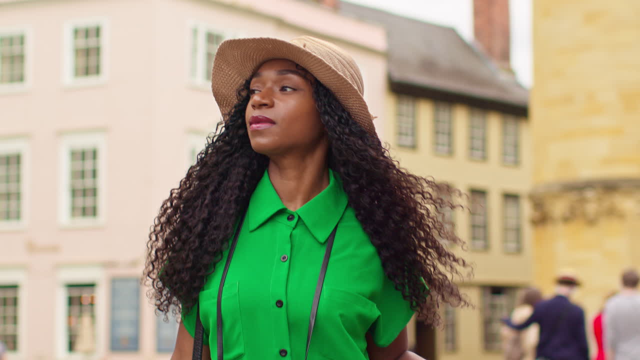 туристка с камерой в отпуске в оксфорде, великобритания, исследует город, идет по широкой улице, толкает чемодан на колесах 2.