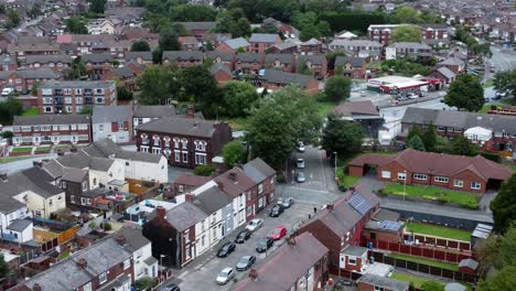 aerial orbit right view above british neighbourhood small town residential suburban property gardens and town streets