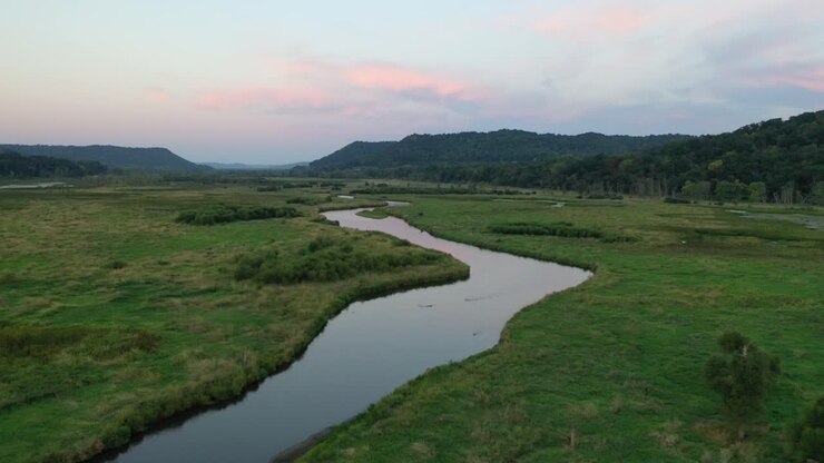 Serene River Winding Through a Valley at Sunset