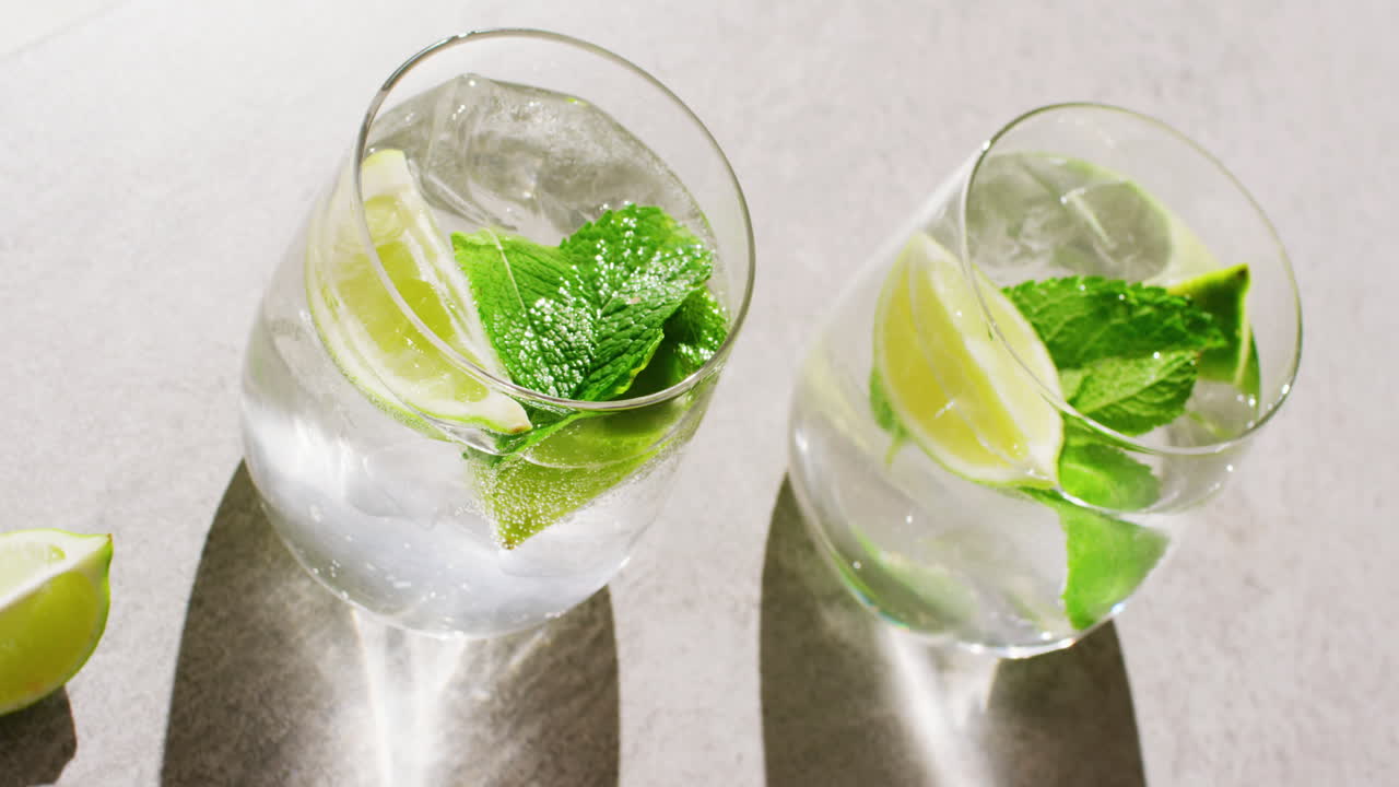 회색 테이블에 누워 있는 레몬과 민트와 함께 두 가지 음료의 가까운