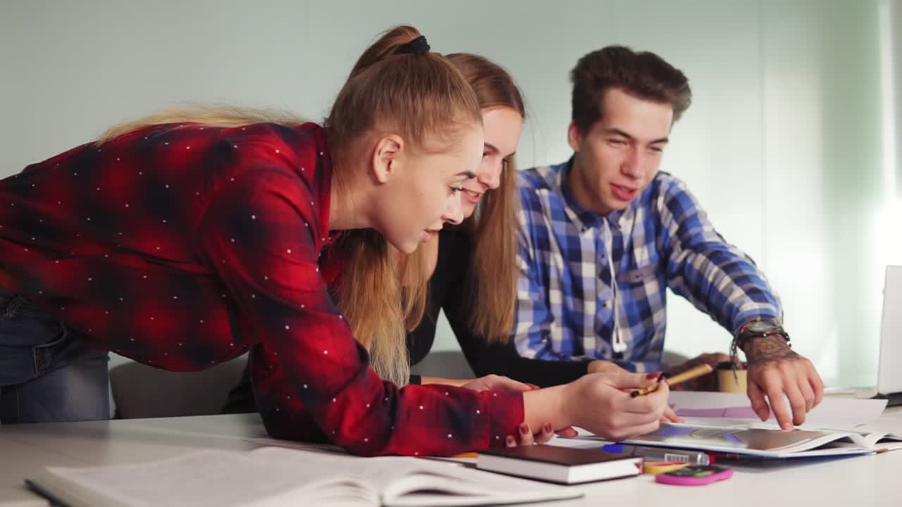 equipo de negocios creativo de tres personas que se reúnen en una oficina moderna. una mujer apuntando su lápiz al papel para mostrar algo