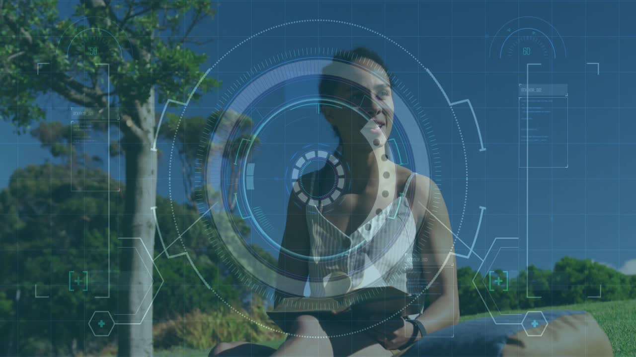 Animation of statistics and graphs over woman sitting on grass reading book in park
