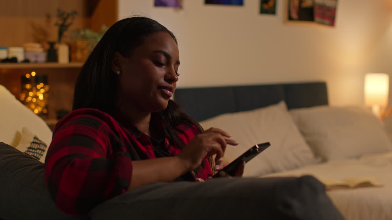 Woman using a smartphone in a bedroom at night