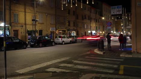 italian town night traffic timelapse - traditional buildings with passing vehicles and pedestrians