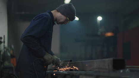 Cámara-Baja:-Un-Hombre-Con-Gafas-Trabaja-Con-Pulido-De-Metal-Y-Desmontaje-De-Estructuras-Metálicas-De-Acero.