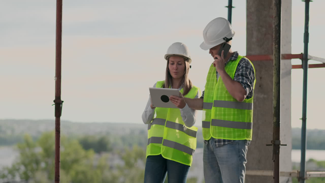 el controlador es un hombre de un edificio en construcción hablando por teléfono con la administración y ha discutido con el ingeniero y la arquitecta el progreso de la construcción.