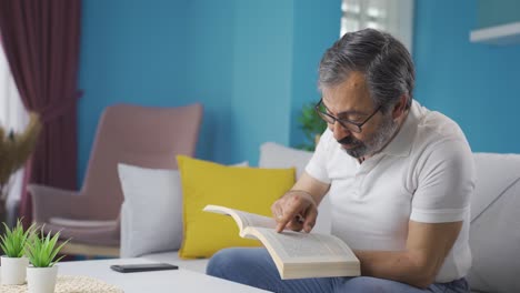 Un-Hombre-De-Mediana-Edad-Está-Leyendo-Un-Libro-Y-Emocionándose.