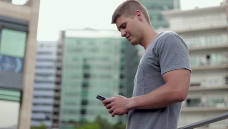 Smiling-man-using-smartphone-outdoor