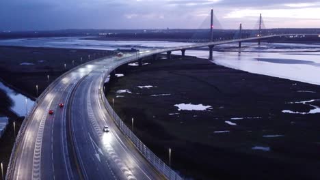 aerial view mersey gateway illuminated freeway bridge overpass lanes early morning sunrise dolly right over traffic