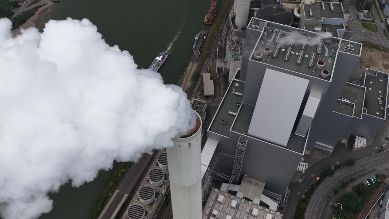 Large scale power plant in Mannheim, Smoking chimney, smoke stack. Aerial close up video of industrial estate at daytime
