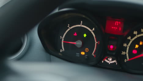 close up of analog car dashboard and vehicle gauge screen with blinking led lights and indicator needles in slowmo