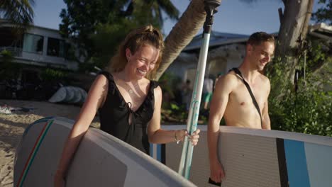 couple enjoying paddleboarding on a tropical beach