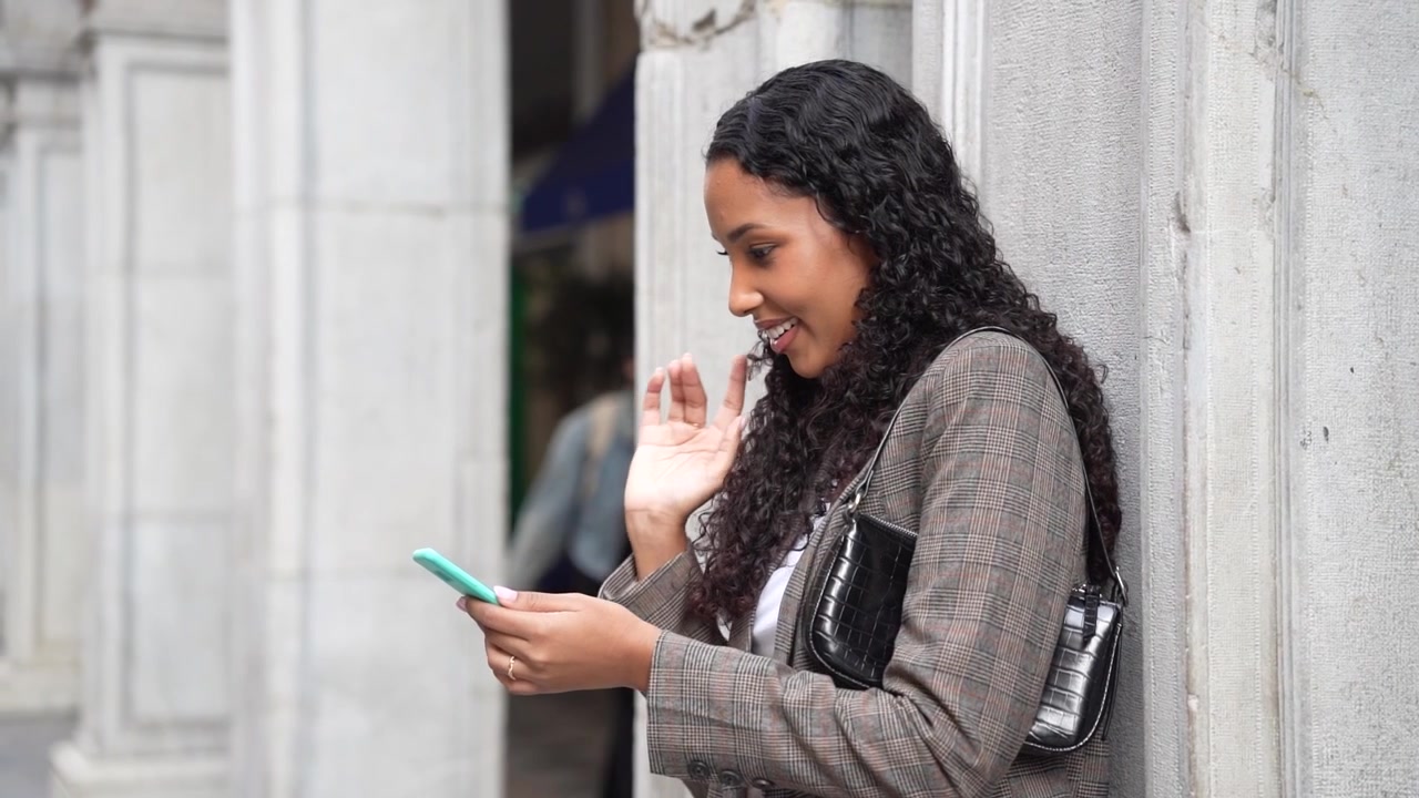 Una giovane donna sta messaggiando sul suo smartphone in un vivace ambiente e paesaggio urbano.