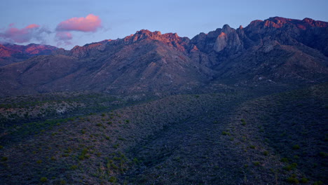 dramatic sunset drone shot with desert mountain landscape below