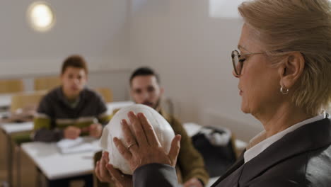 teacher explaining anatomy with skull model