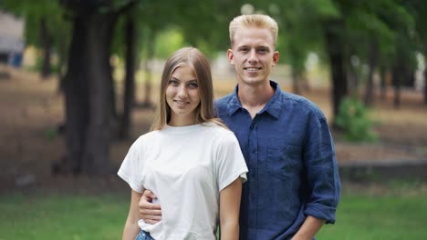 Hermosa-Pareja-Joven-Posando-Con-El-Telón-De-Fondo-Del-Parque.-Ir-A-Caminar.-Cita-Romántica.-Rubias.-Felicidad