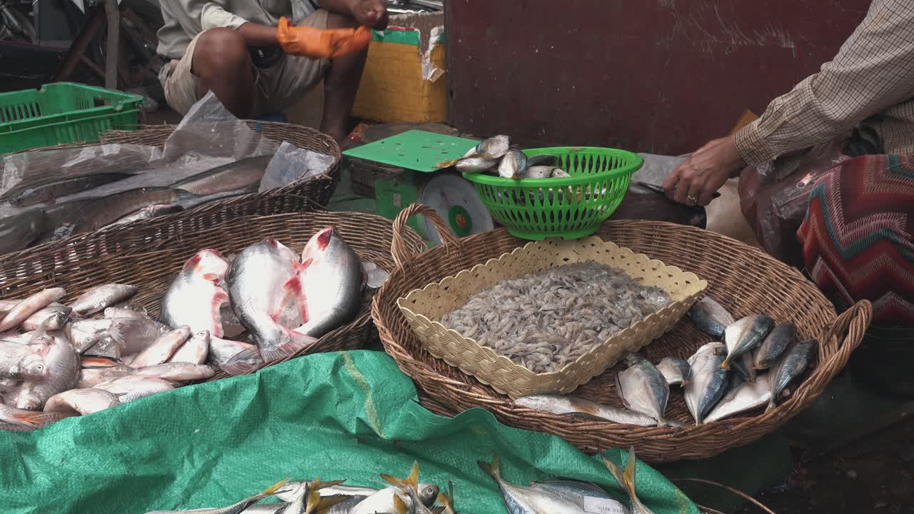 comerciantes del mercado preparando pescado para la venta