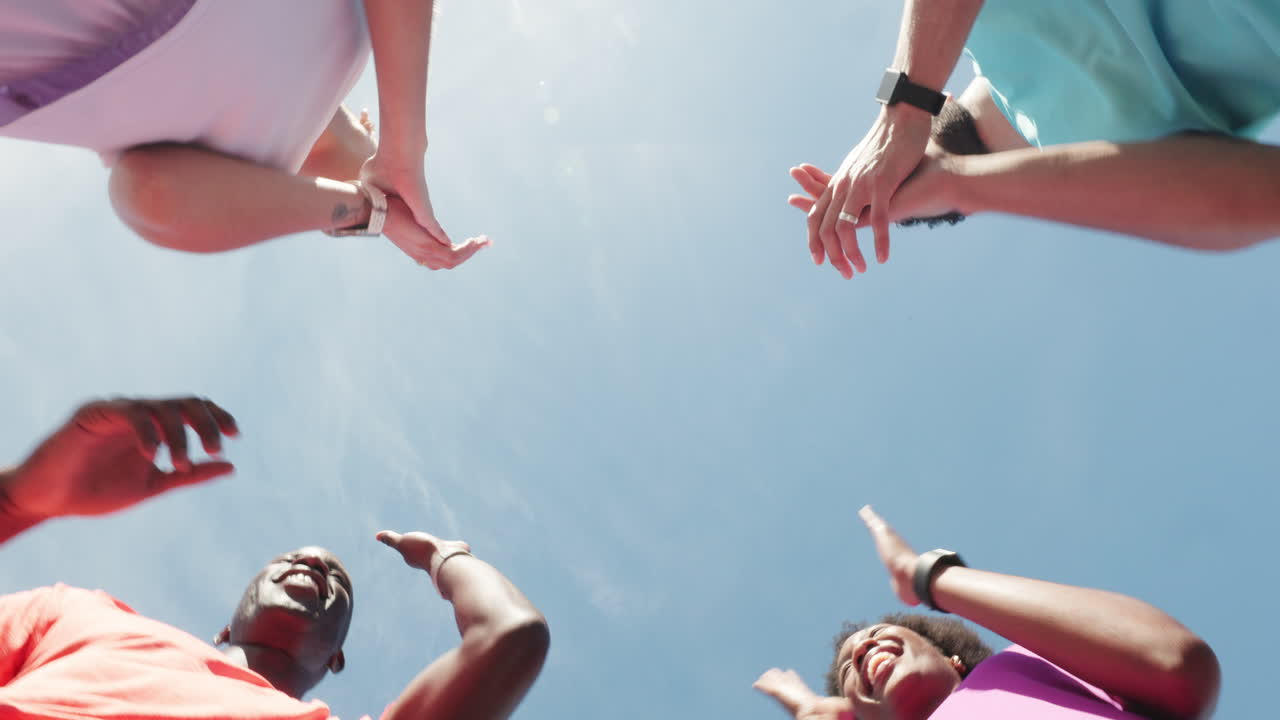 Diverse Group of People Clapping Hands in a Circle Under Blue Sky
