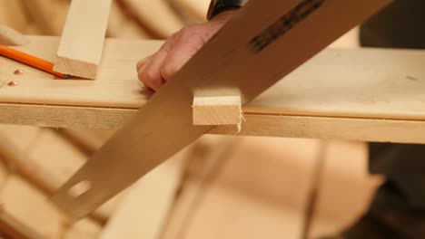 craftsman manually sawing wood in traditional boat building