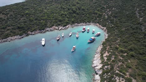 Drone-of-boats-parked-in-shallow-crystal-blue-waters-on-the-Turkish-Riviera-in-Bodrum