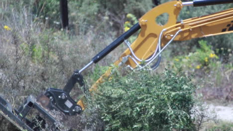 close-up-and-slow-motion-shot-of-plant-machinery-cutting-and-destroying-a-semi-dry-bush-in-Spain