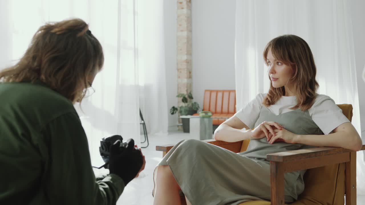 Attractive Woman Sitting in Armchair and Posing during Studio Photo Session