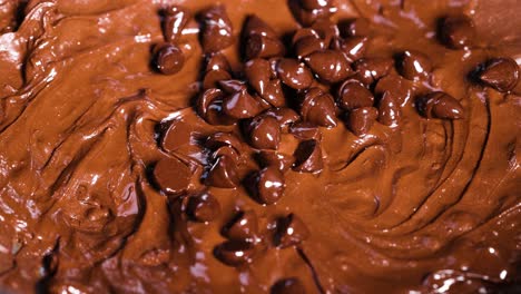 chocolate chips being mixed into smooth batter