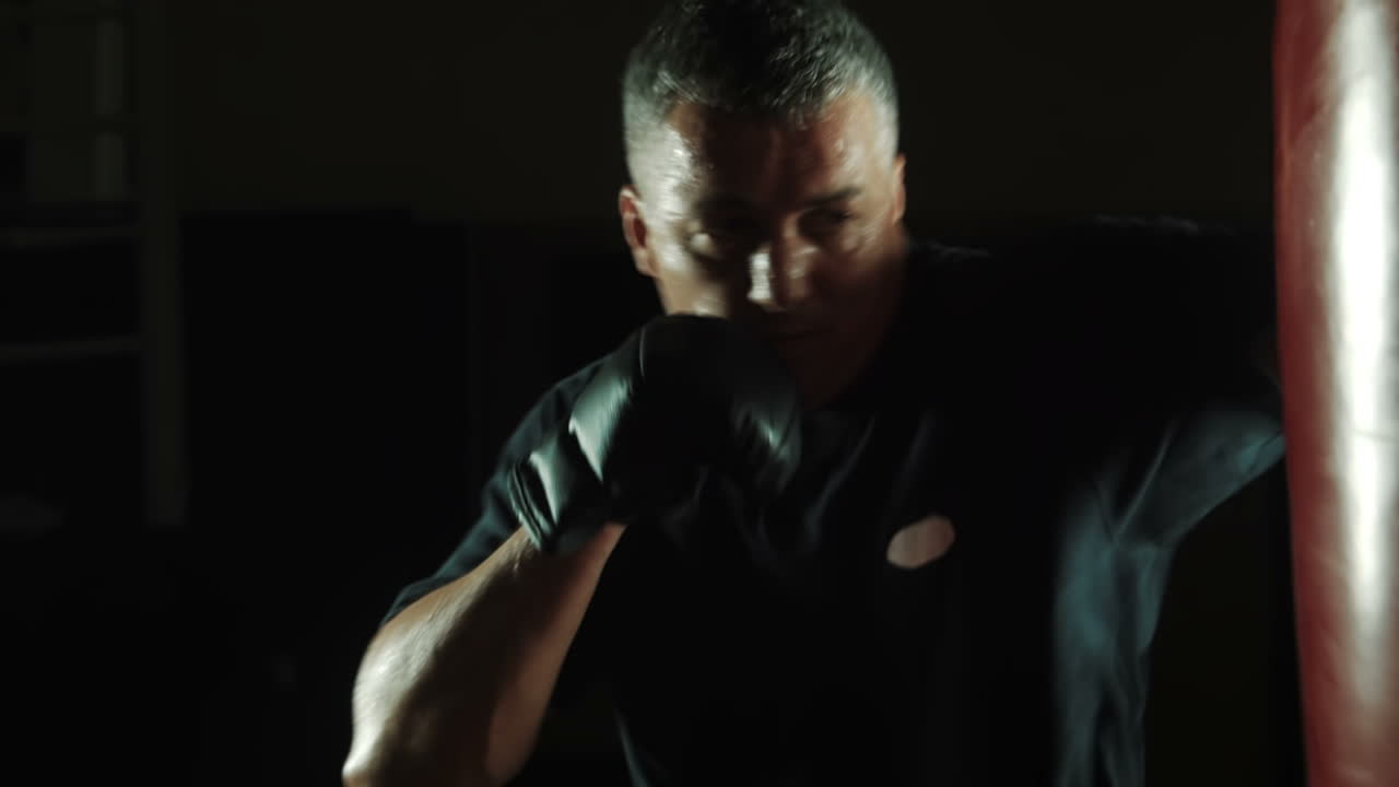 Workout Of Boxer With Sweaty Face Hitting Red Bag (Stock Footage)