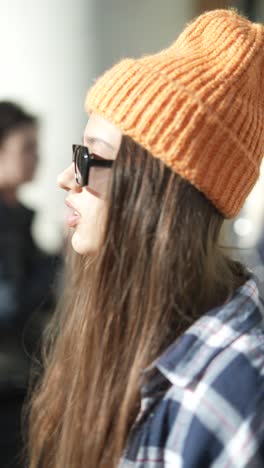 woman with orange knitted hat and sunglasses