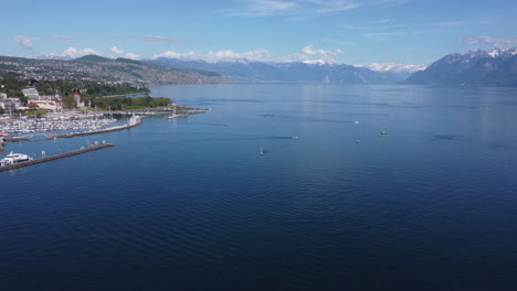 slow aerial descent shot of a sail boat on lake geneva in lausanne, switzerland on a sunny day