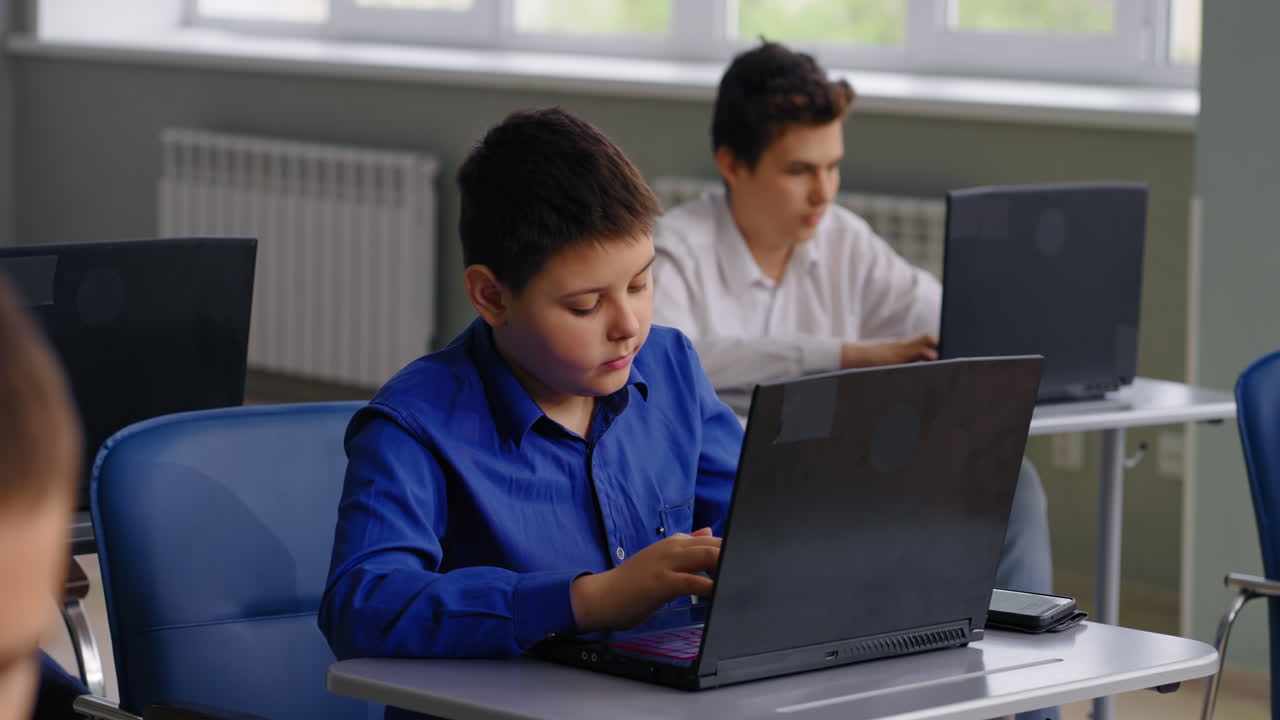 estudiantes trabajando en computadoras portátiles en un aula