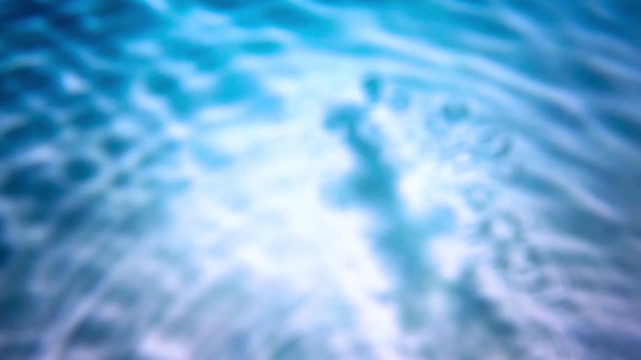 Increspature astratte di acqua blu e riflessi di luce.