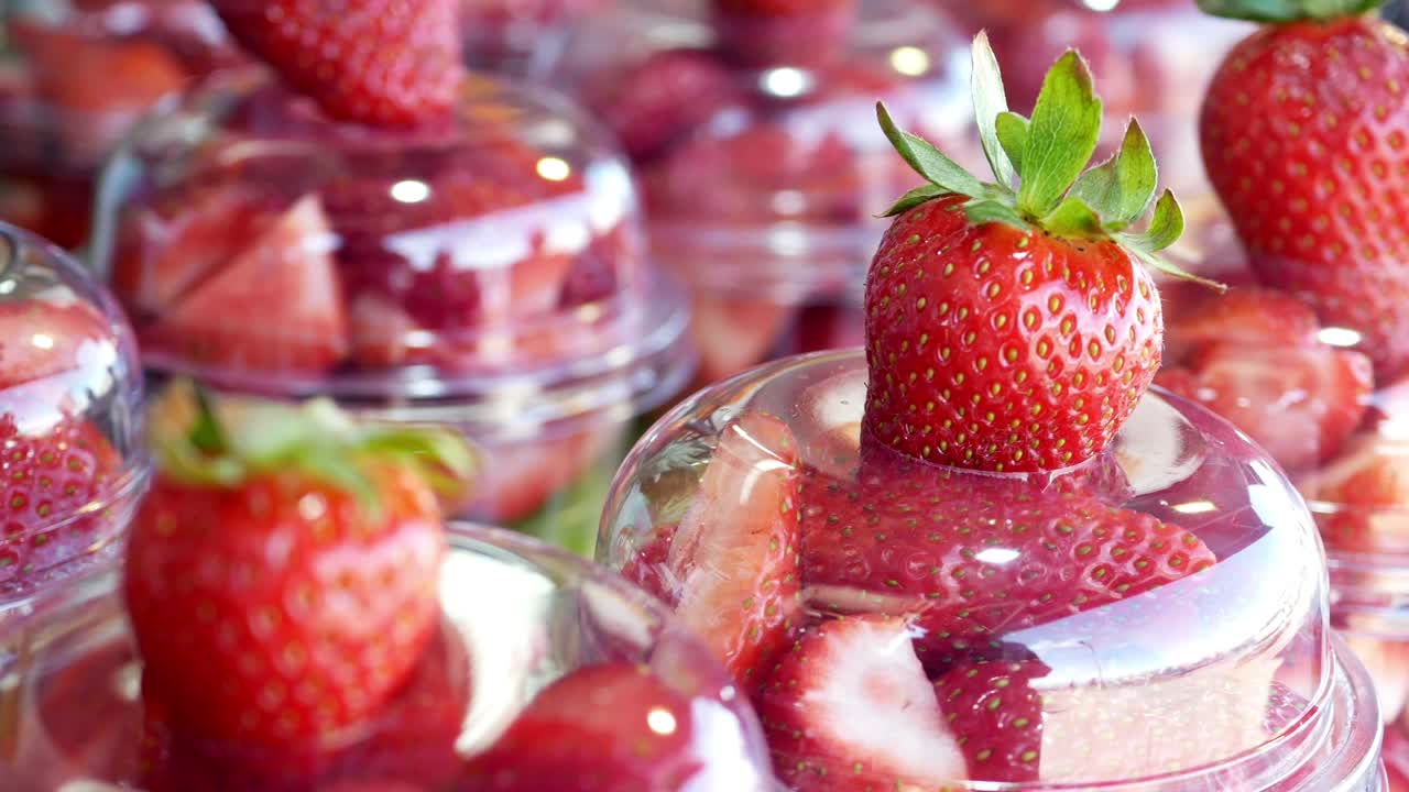 fresas en rodajas en vasos de plástico