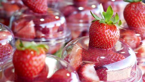 fresh sliced strawberries in plastic cups