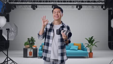 Photographer showing OK sign in a studio