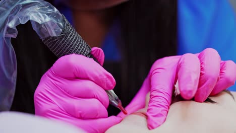 cosmetology procedure on lips. modern tattoo machine in beautician hands during the permanent make-up on lips.